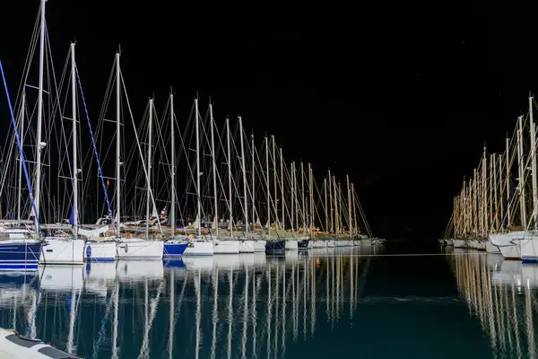 Sailing yachts in marina at night time. Mediterranean yacht port with sailing boats. Darkness. Calm weather. Yachting concept.