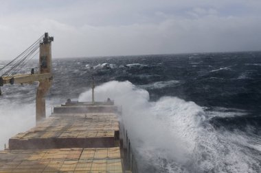 Kargo gemisi fırtınalı denizde kargo taşıyor. Seyir köprüsünden görüntü. Fırtınalı deniz, kötü hava. Gale. Dalgalı deniz.