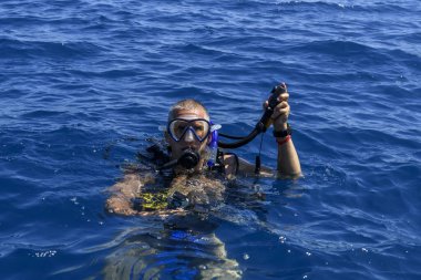 Erkek dalış dalgıcı suya dalmaya hazırlanıyor. Su altı sporları ve aktivite konsepti.