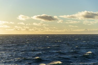 Güzel deniz manzarası. Dalgalar, bulutlar ve güzel ışıklandırmalı gökyüzü. Altın saat.