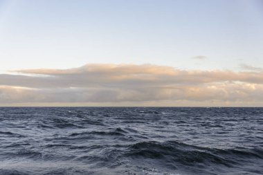 Güzel deniz manzarası. Dalgalar, bulutlar ve güzel ışıklandırmalı gökyüzü. Altın saat.