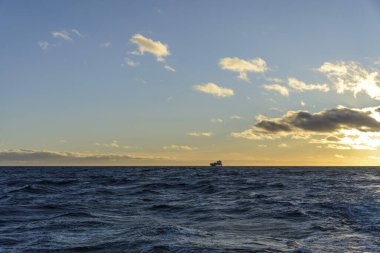 Güzel deniz manzarası. Dalgalar, bulutlar ve güzel ışıklandırmalı gökyüzü. Altın saat.