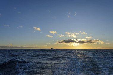 Güzel deniz manzarası. Dalgalar, bulutlar ve güzel ışıklandırmalı gökyüzü. Altın saat.