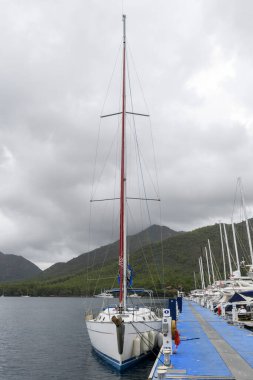 Sailing yacht berthed alongside in marina. Blue sky with clouds and sun. Tall ship. Yachting concept.