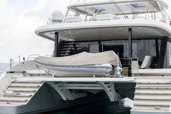Inflatable tender motor boat on swim platform of superyacht. Inflatable dinghy with outboard engine. Power boat.
