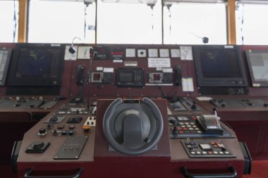 Geminin kontrol cihazı. Seyir köprüsünden motor kontrolü. Dümene odaklanmış, mavi arkaplan.