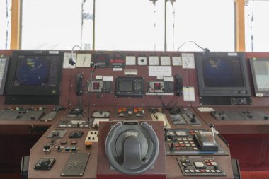 Geminin kontrol cihazı. Seyir köprüsünden motor kontrolü. Dümene odaklanmış, mavi arkaplan.