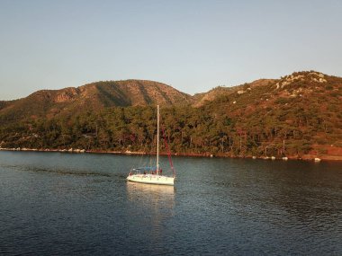 İnsansız hava aracının deniz manzarasında yelkensiz yelkenli kullanmak. Mavi deniz suyu. Yelkenli tekneleri olan bir Akdeniz yat limanı. Yatıcılık konsepti.
