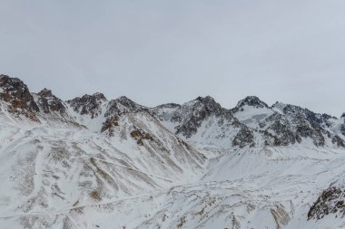 Kış dağı manzarası. Tepeler, kayalar ve buzullar. Kazakistan doğası.