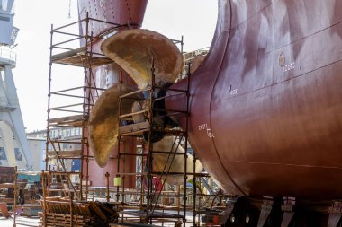 Gemi tamirhanesindeki kargo gemisi kuru rıhtımda. Değişken pervane ve dümen.