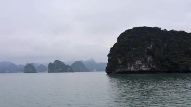 Ha Long Bay, Vietnam. Denizde dağlar. Yağmurlu ve bulutlu hava.