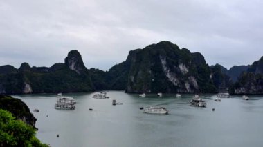 Ha Long Bay, Vietnam. Dağlar ve tekneler denizde. Yağmurlu ve bulutlu hava.