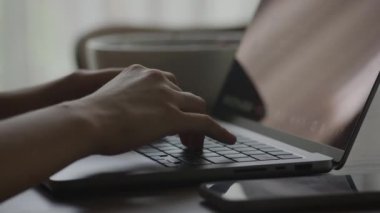Eller klavyede daktilo ediyor. Yakın çekim. Dizüstü bilgisayar kullanan kadın. Tanımlanamayan kadın kollarının etrafında dönmek bilgisayarın içinde ağır çekimde çalışmak.