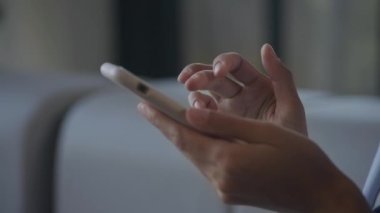 Swiping on smartphone. Woman hand scrolling on smart phone in slow motion indoors
