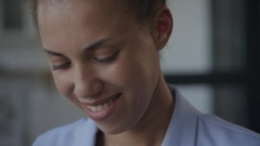 Woman face reading and smiling close up. Pivoting around shot of a happy African American businesswoman in slow motion