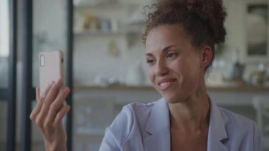 Businesswoman talking on a video call using smartphone. African American woman smiling and discussing plans on a conference call on her phone