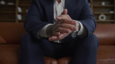 Extreme closeup of tattooed businessman hands wearing a suit in slow motion