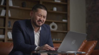 Businessman turning down job offer. An Asian man with a laptop in negative emotions