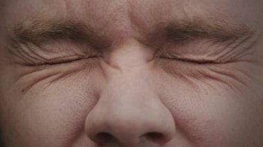 Blue eyes open in slow motion extreme close up looking at camera