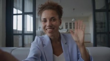 POV woman greeting on video conference call. African American businesswoman holding a smartphone during a video meeting - webcam view on a selfie camera