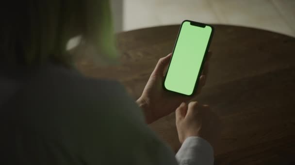 女性はスワイプし スローモーションで屋内緑の画面クロマキーとスマートフォンで見て — ストック動画