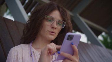 Disappointed woman browsing online on smartphone outside in slow motion