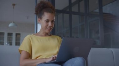 Excited entrepreneur working on laptop indoors. African American Woman reading good news on computer