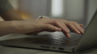 Kadın elleri dizüstü bilgisayarda, kadın kolları içeride daktilo ediyor.