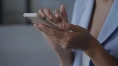 Woman hands browsing on smartphone extreme close up - scroll and swipe with her fingers and wearing a suit in slow motion