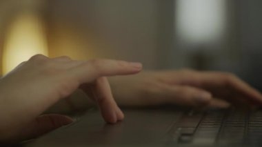 Efficient Laptop Productivity: Womans Hands on Touchpad. Close-up of a womans hands quickly scrolling on a laptop touchpad, with a background view of a cozy indoor space.