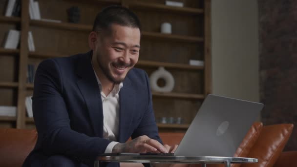 비즈니스 컴퓨터를 사용하는 아시아 남자와 웃으며 온라인을 탐색하고 사무실에서 컴퓨터로 — 비디오