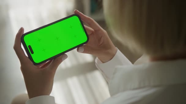 緑色の画面のスマートフォン クロマキー電話モックアップをシングルタップします 認識できない原因アジアの女性保持水平スマートフォンで彼女の手室内で60Fps — ストック動画