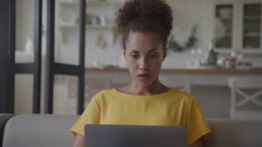 Başı dertte olan bir kadın, dizüstü bilgisayardan Kötü Haberler okuyor. Afrikalı Amerikalı yetişkin bilgisayardaki bir mesajla şok oldu ve hayal kırıklığına uğradı.