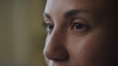 Bir kadının gözleri aşırı yakın-yan görüş. Afrika kökenli Amerikalı bir kadının yüzünü yavaş çekimde evin içinde döndürmek.