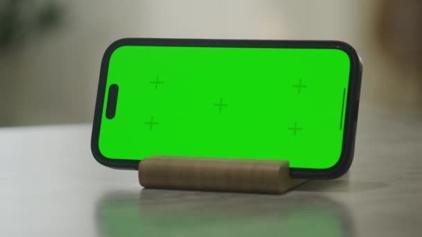 緑の画面で水平方向のスマートフォンの周りにピボット Chromaキースマートフォンのモックアップ Fpsでアパートでドリーで撮影 — ストック動画