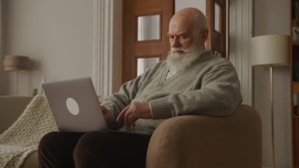 Старший Использует Ноутбук Дедушка Работает Компьютером Своей Квартире — стоковое видео