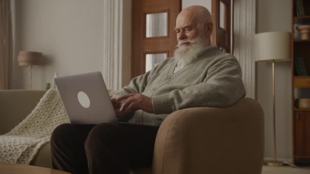 Yaşlı Adam Dizüstü Bilgisayarda Çalışıyor Büyükbaba Içeride Bilgisayar Kullanıyor — Stok video
