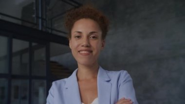 Gülümseyen İş kadını Portresi, girişimci ağır çekimde el kamerasına bakıyor.