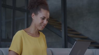 Konferans Çağrısında Dizüstü bilgisayar kullanan bir kadın. Afrikalı Amerikalı bir kadın bir video konuşmasında konuşuyor.