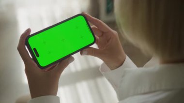 Yatay Yeşil Ekran Akıllı Telefonu 'nda Jestleri Yukarı Kaydır. Krom anahtar kullanan tanınmayan bir kadının omuz manzarası. Akıllı telefon modeli.