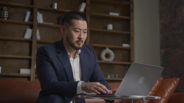 ビジネスマンがオフィスでノートパソコンで悪いニュースを読んで 訴訟の韓国の起業家は心配しています — ストック動画