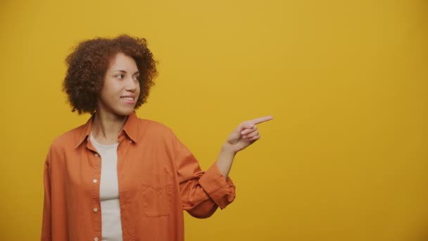 Woman Point Finger Miejscu Kopiowania Patrząc Aparat Fotograficzny Żółtym Tle — Wideo stockowe