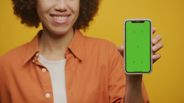 Frau Zeigt Smartphone Mit Grünem Bildschirm Auf Gelbem Hintergrund Unkenntliche — Stockvideo