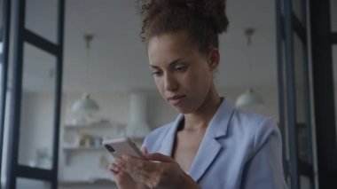 Takım Elbiseli Duygusal Kadın Smartphone 'a bakıyor, İş kadını internette gülümseyerek akıllı telefon kullanıyor.