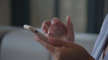 İş kadını elleri akıllı telefonda geziniyor. İçeriyi yavaş çekimde kapatın.