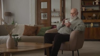 Büyükbaba Akıllı Telefon Kullanıyor, Kıdemli Adam Çevrimiçi Apartmanda Akıllı Telefona Bakıyor