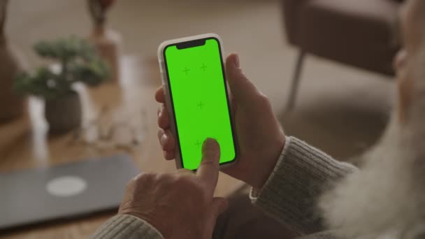 老年人在绿色屏幕智能手机上单击掌或按键在肩膀上方看60秒慢动作 祖父轻轻按一下彩色按键智能手机 — 图库视频影像