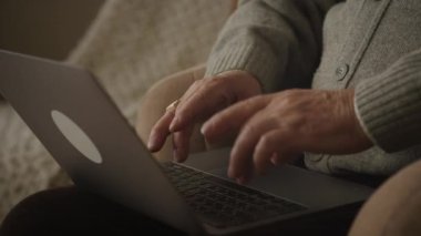 Yaşlı adam elleri daktiloda, dede kolları dizüstü bilgisayar klavyesinde.