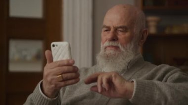Kıdemli Yetişkin Göz gezdirme Akıllı Telefon Yakından, Yaşlı Adam Kaşlarını çatar veya Akıllı Telefon 'dan haber okur