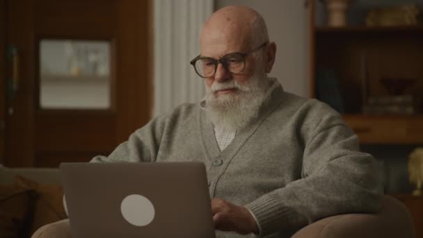 Hombre Mayor Gafas Escribiendo Ordenador Portátil Abuelo Trabajando Computadora Apartamento — Vídeo de stock